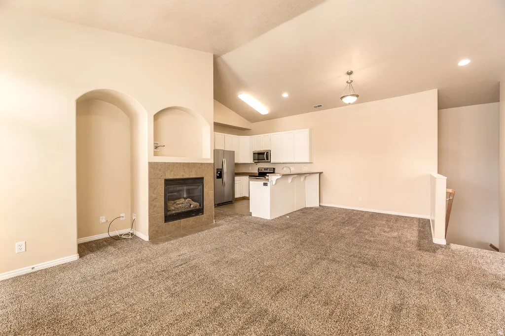 Open-concept living area with vaulted ceilings, recessed lighting, and a neutral color palette