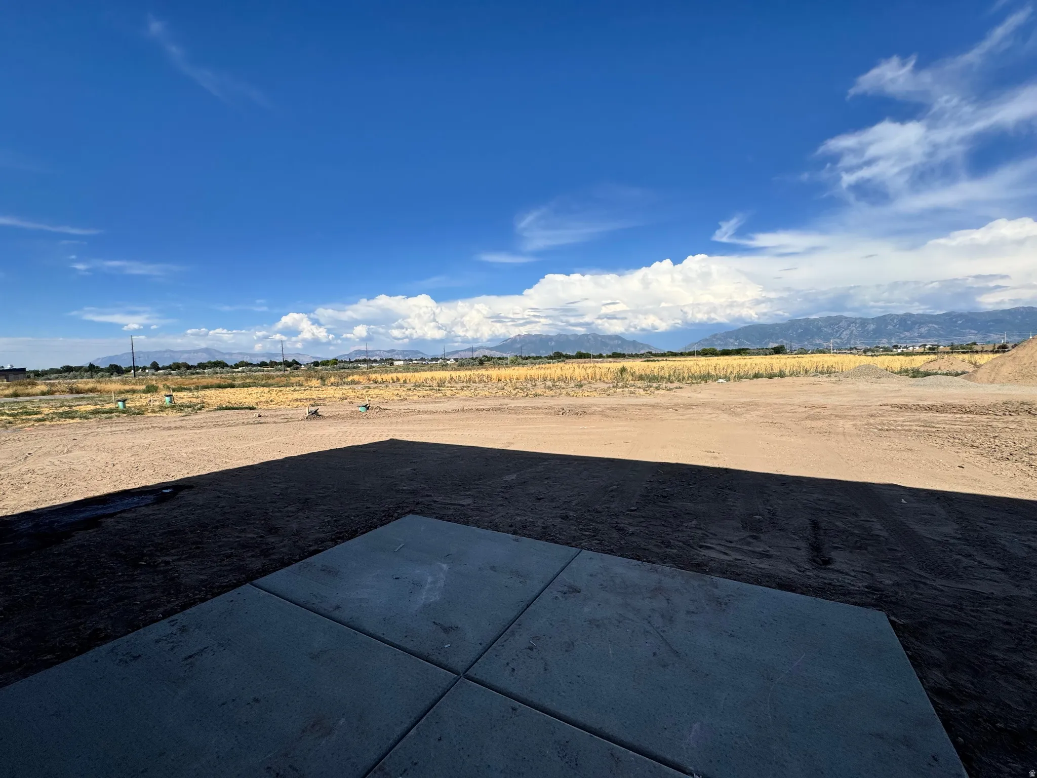 Concrete patio with an expansive, undeveloped lot extending to the horizon
