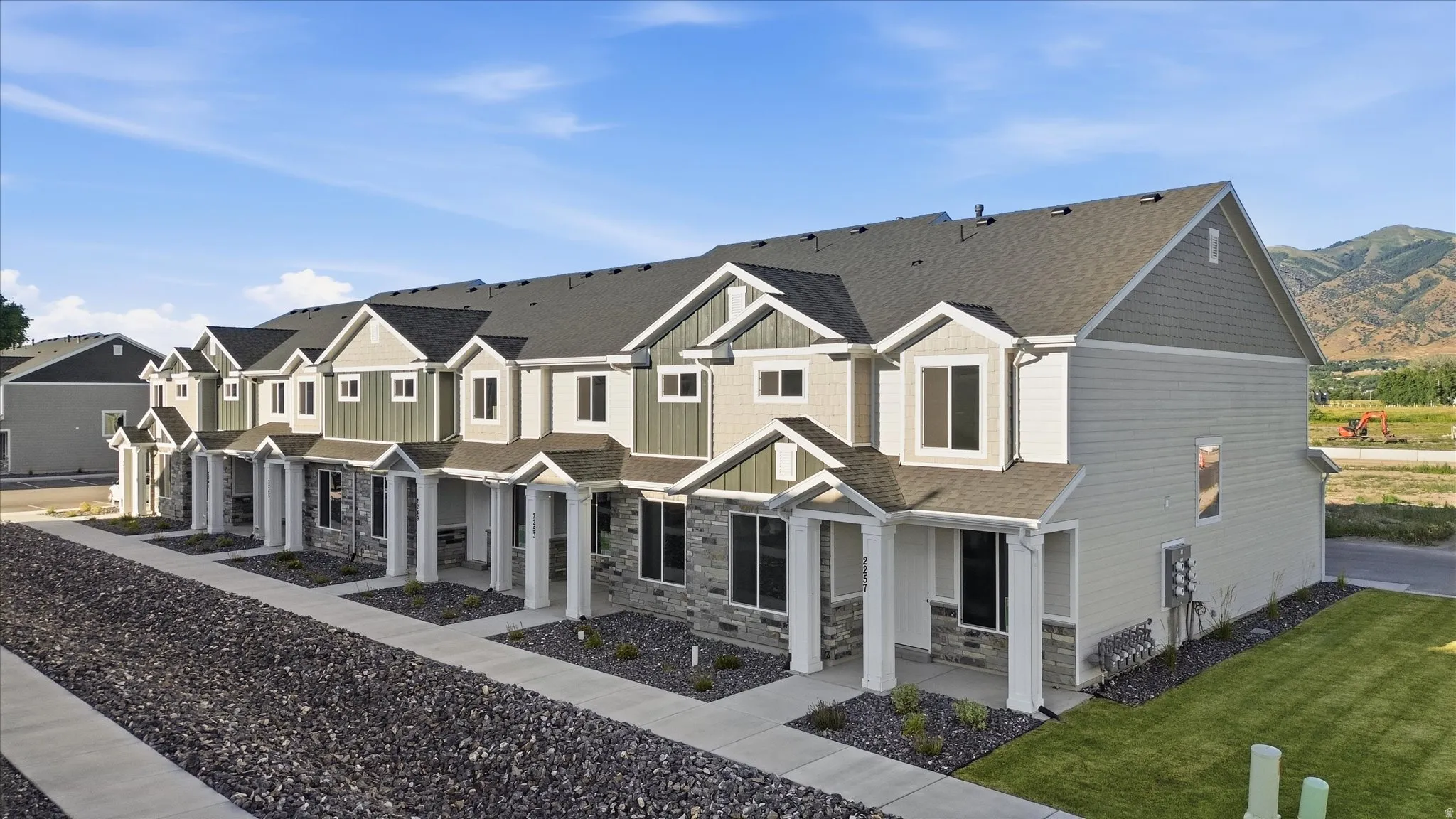 Modern townhome exteriors featuring horizontal siding, vertical siding accents, and stone veneer detailing