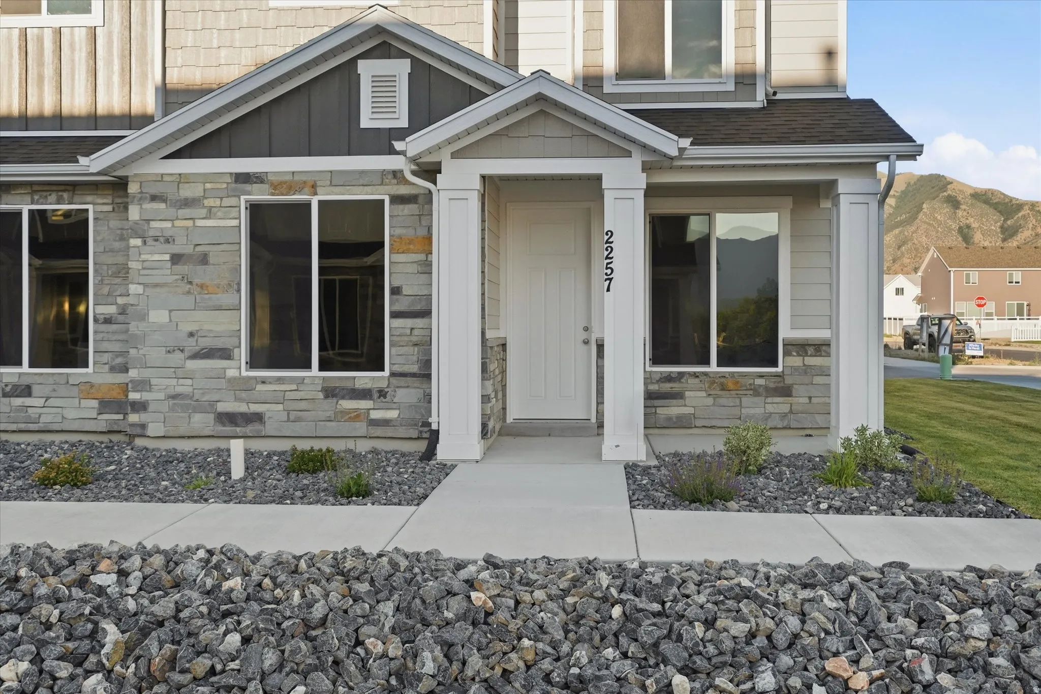 Multi-textured exterior featuring stone veneer, horizontal siding, and shingle accents