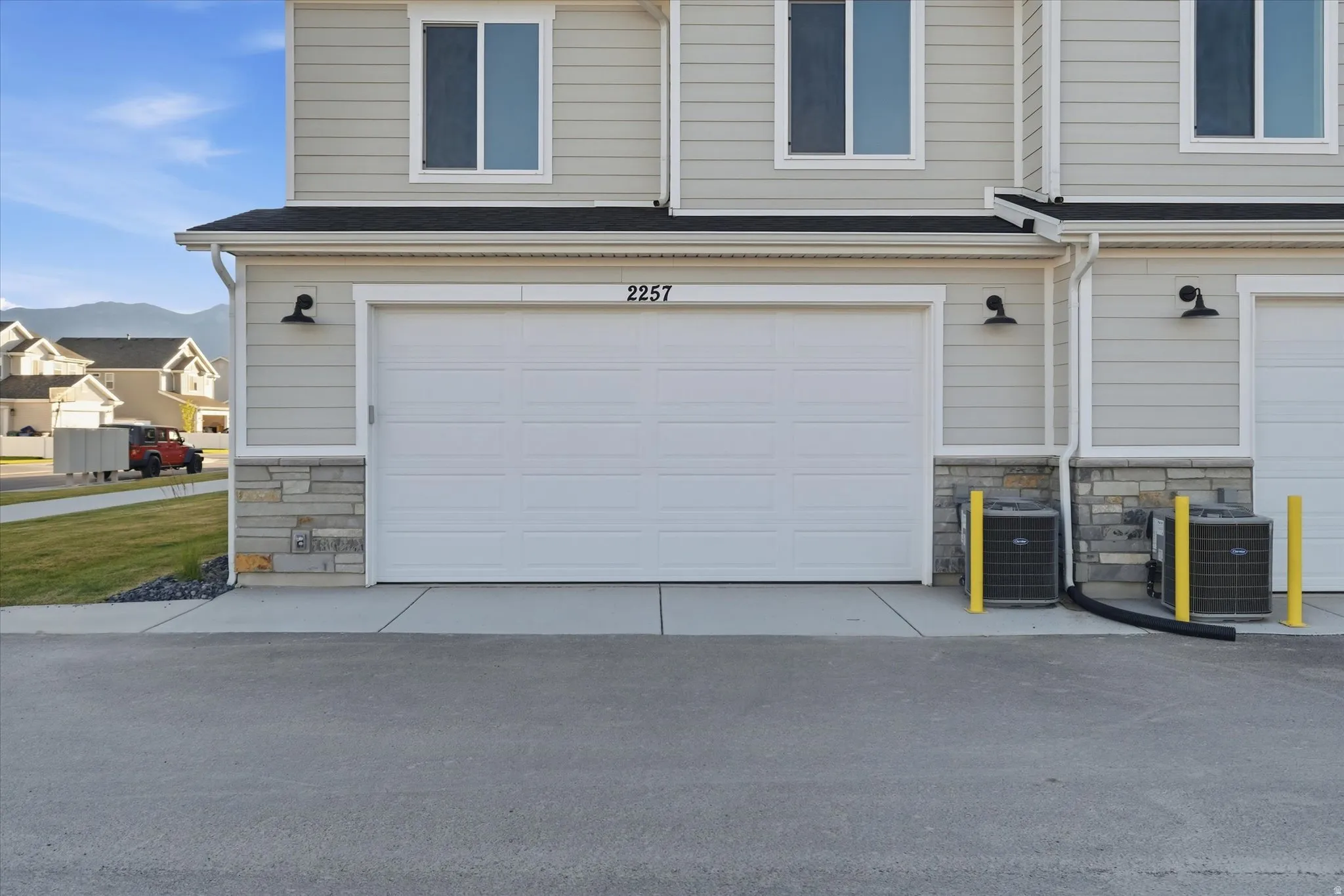 Property exterior featuring light gray horizontal siding and a white garage door