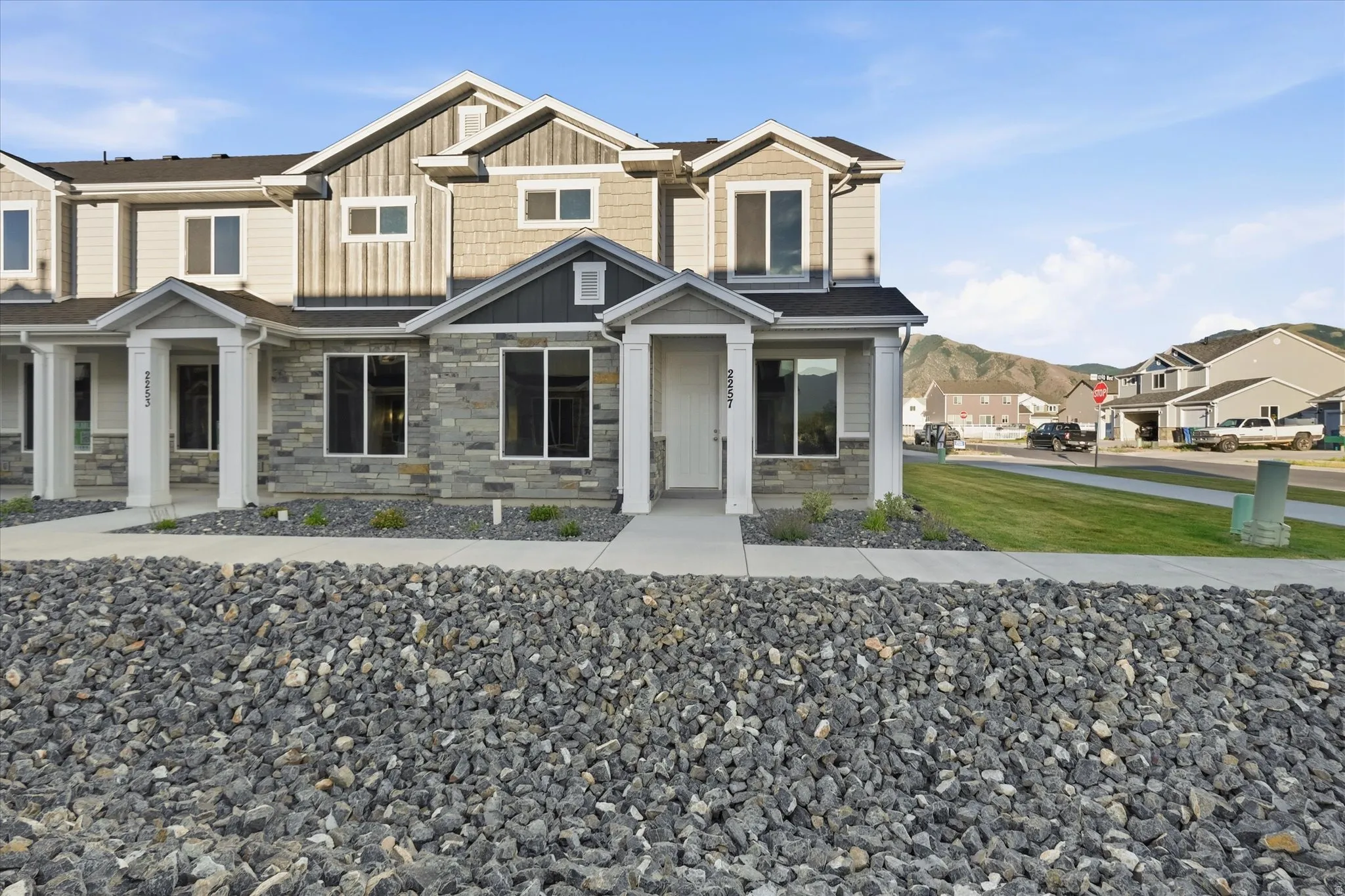 Contemporary multi-level townhome featuring a stone facade and vertical siding accents
