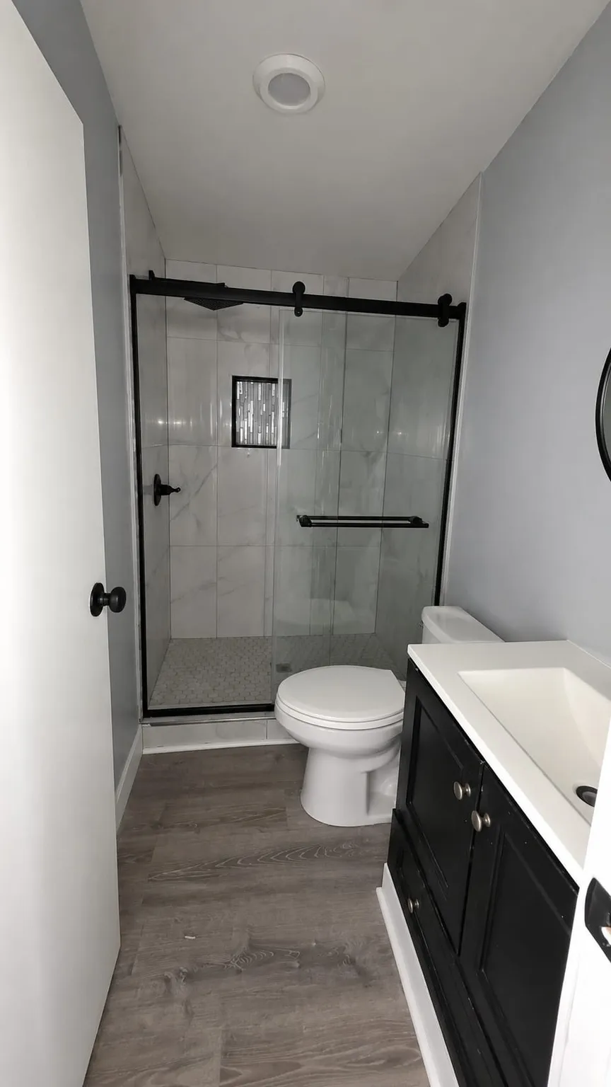 Bathroom featuring a walk-in shower with a black-framed glass enclosure, white subway tile walls, and a recessed niche