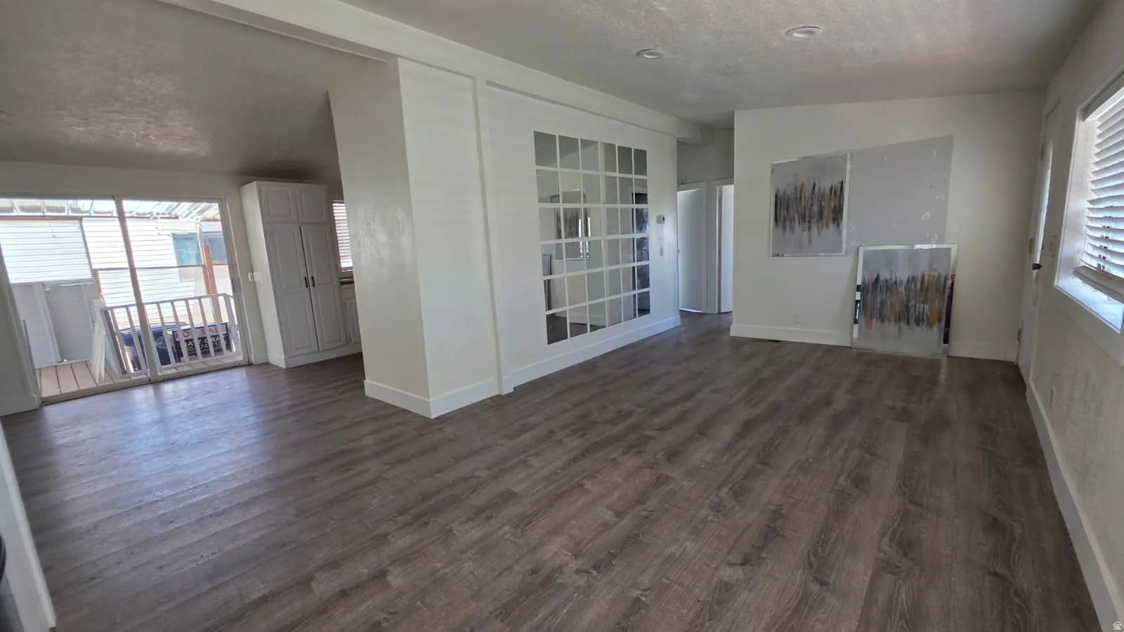Spacious interior featuring wood-finish flooring, white walls, and recessed lighting
