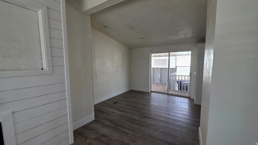 Spacious room featuring wood-finish flooring, recessed lighting, and a sliding glass door leading to an outdoor deck