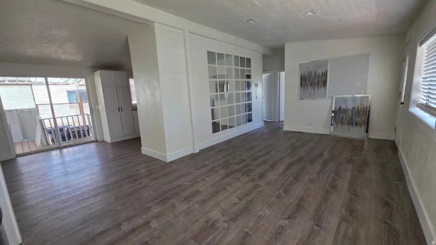 Spacious interior featuring wood-finish flooring, white walls, and recessed lighting