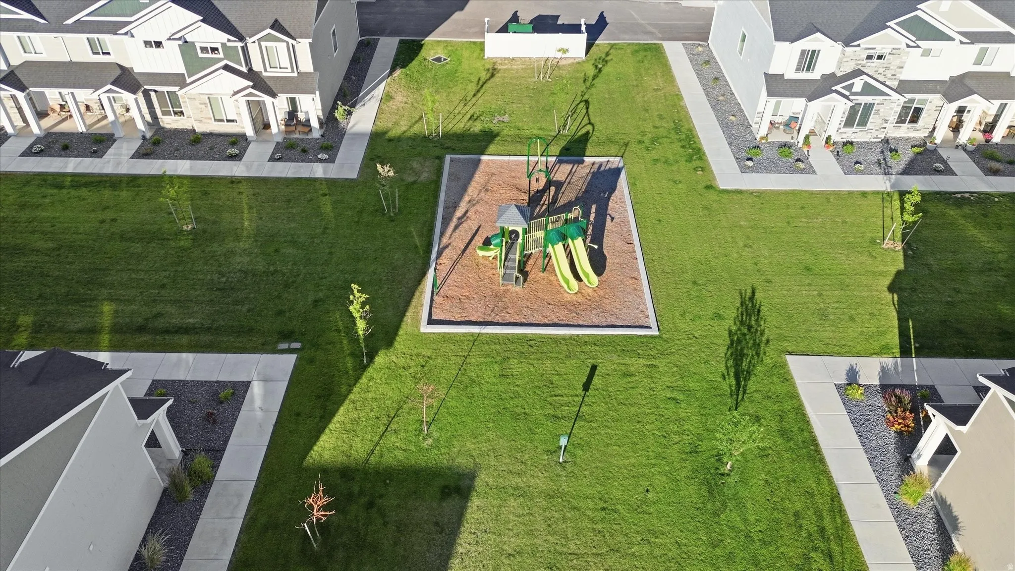 Community green space featuring a central playground with slides and swings