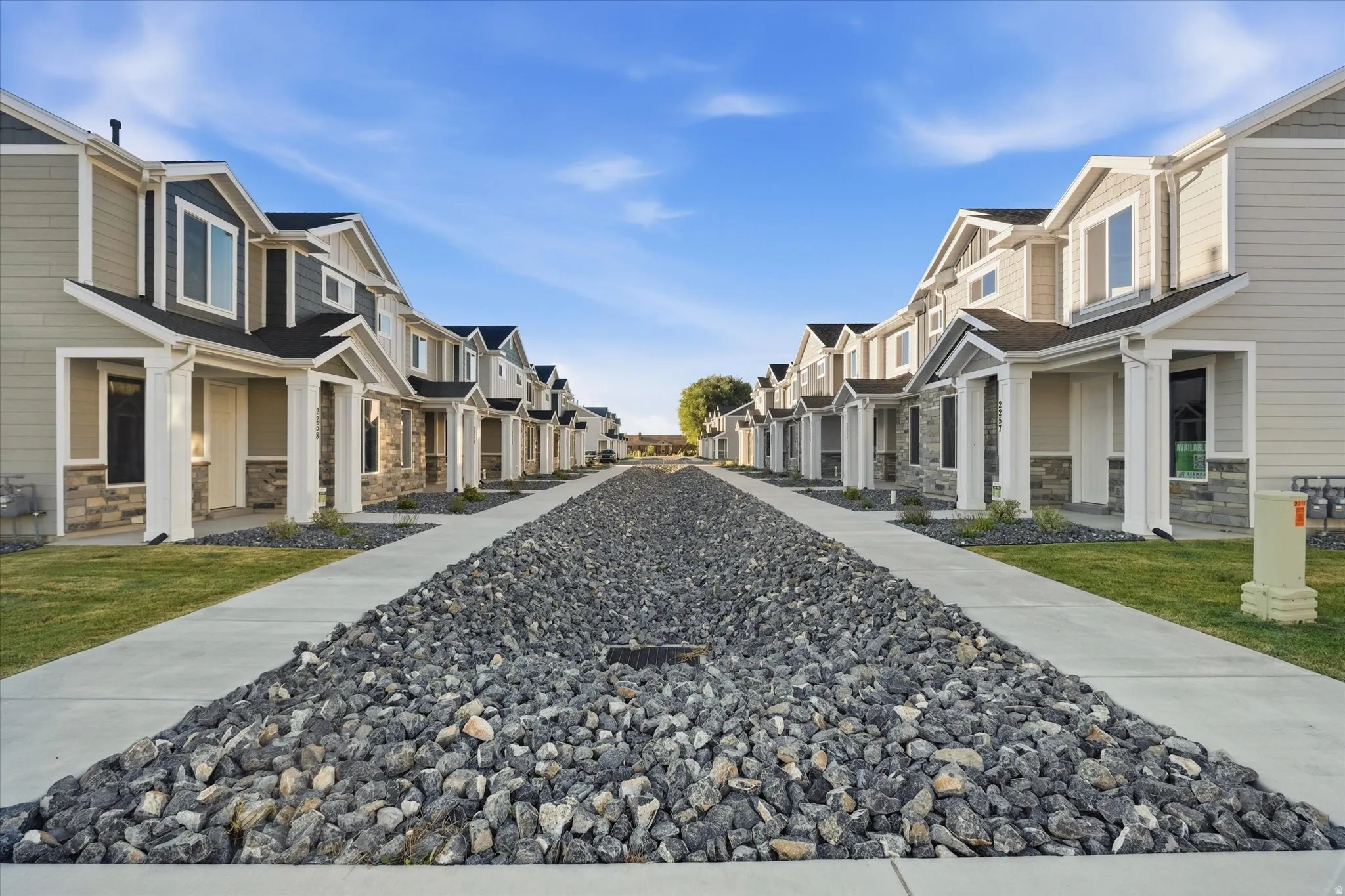 Row of contemporary townhomes featuring multi-toned siding and stone veneer accents