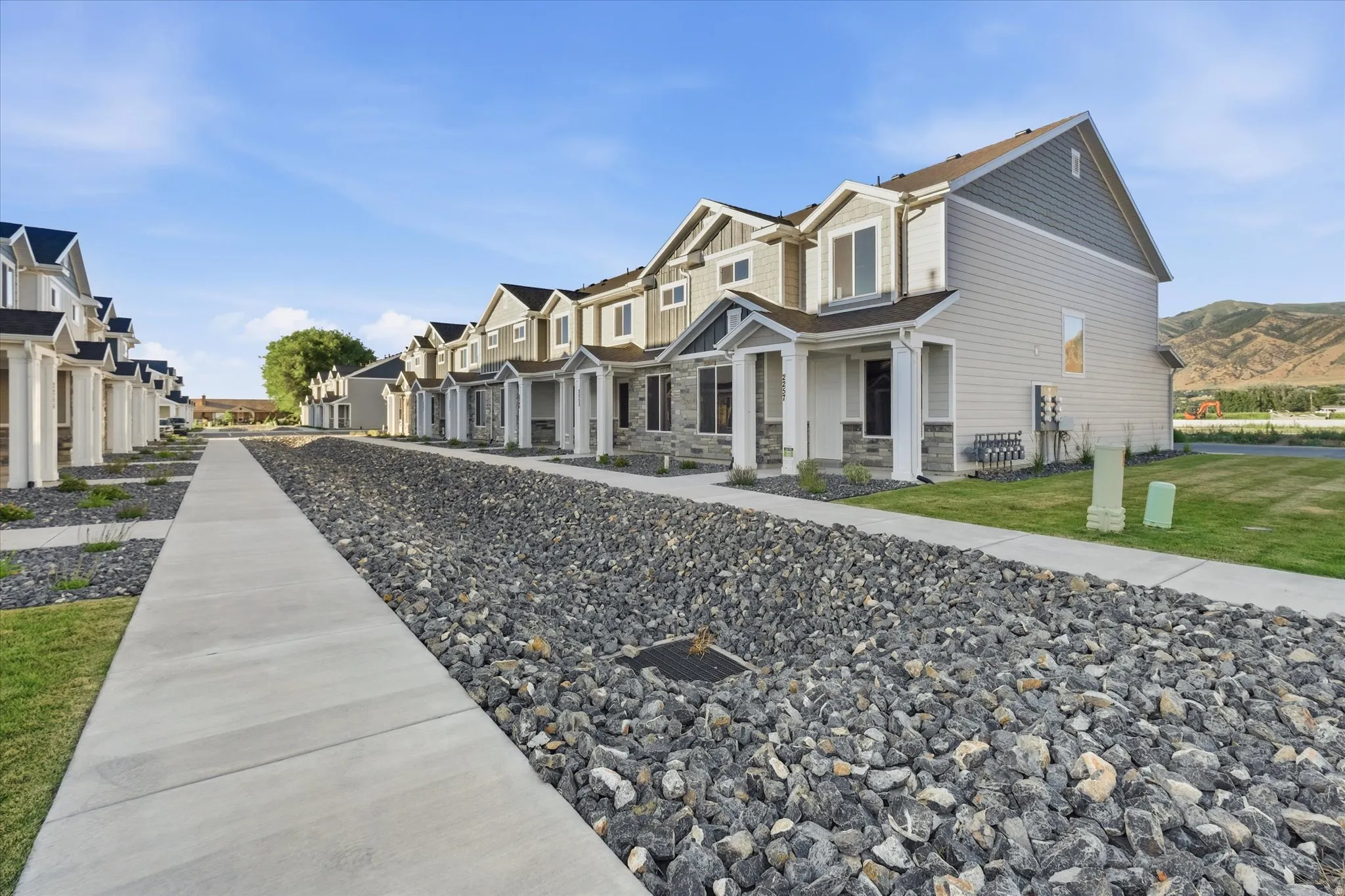 Modern townhome with a multi-textured exterior, including horizontal siding, shaker siding, and stone accents