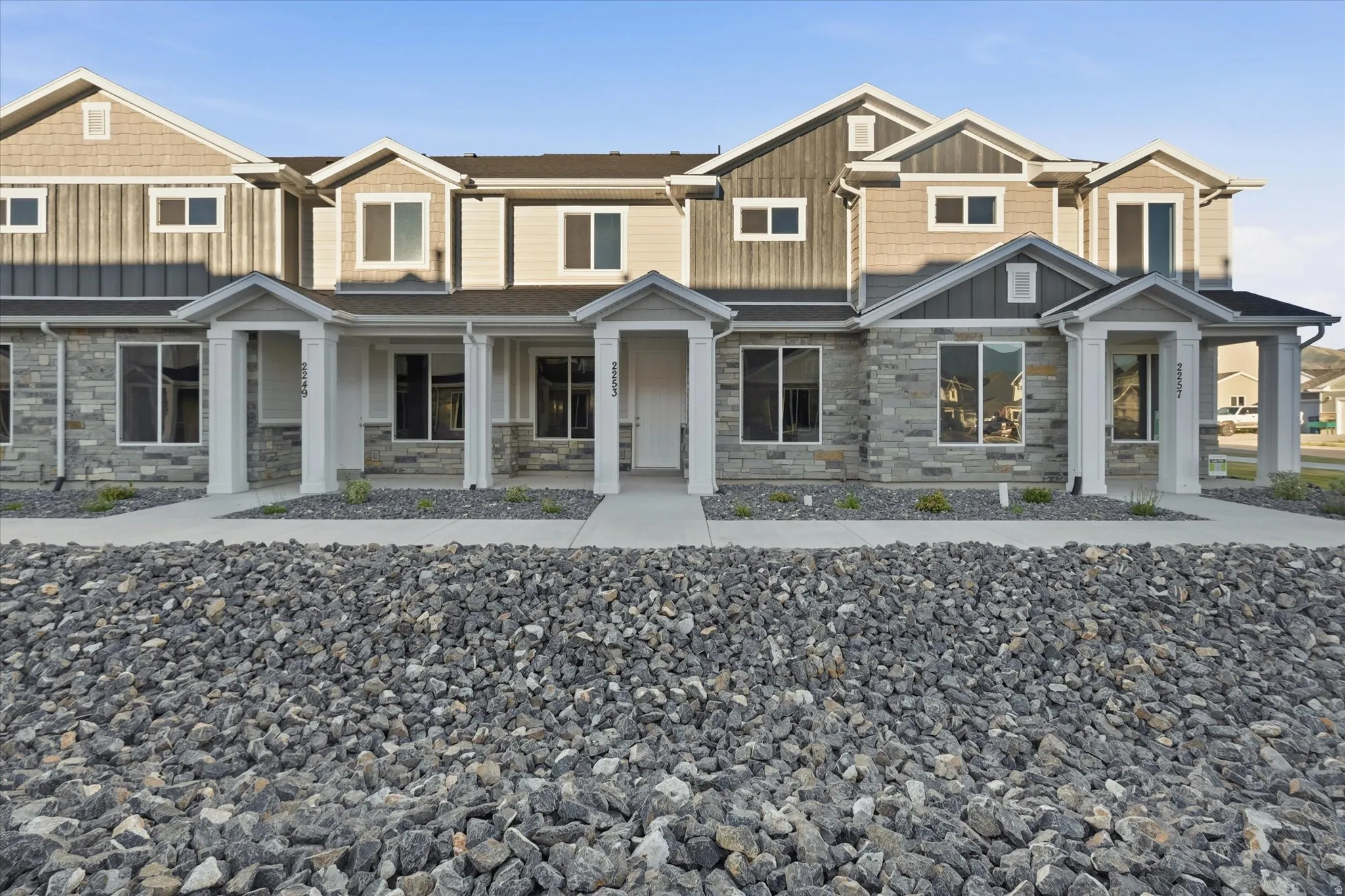 Contemporary townhome-style exterior featuring stone veneer, vertical siding, and shake accents