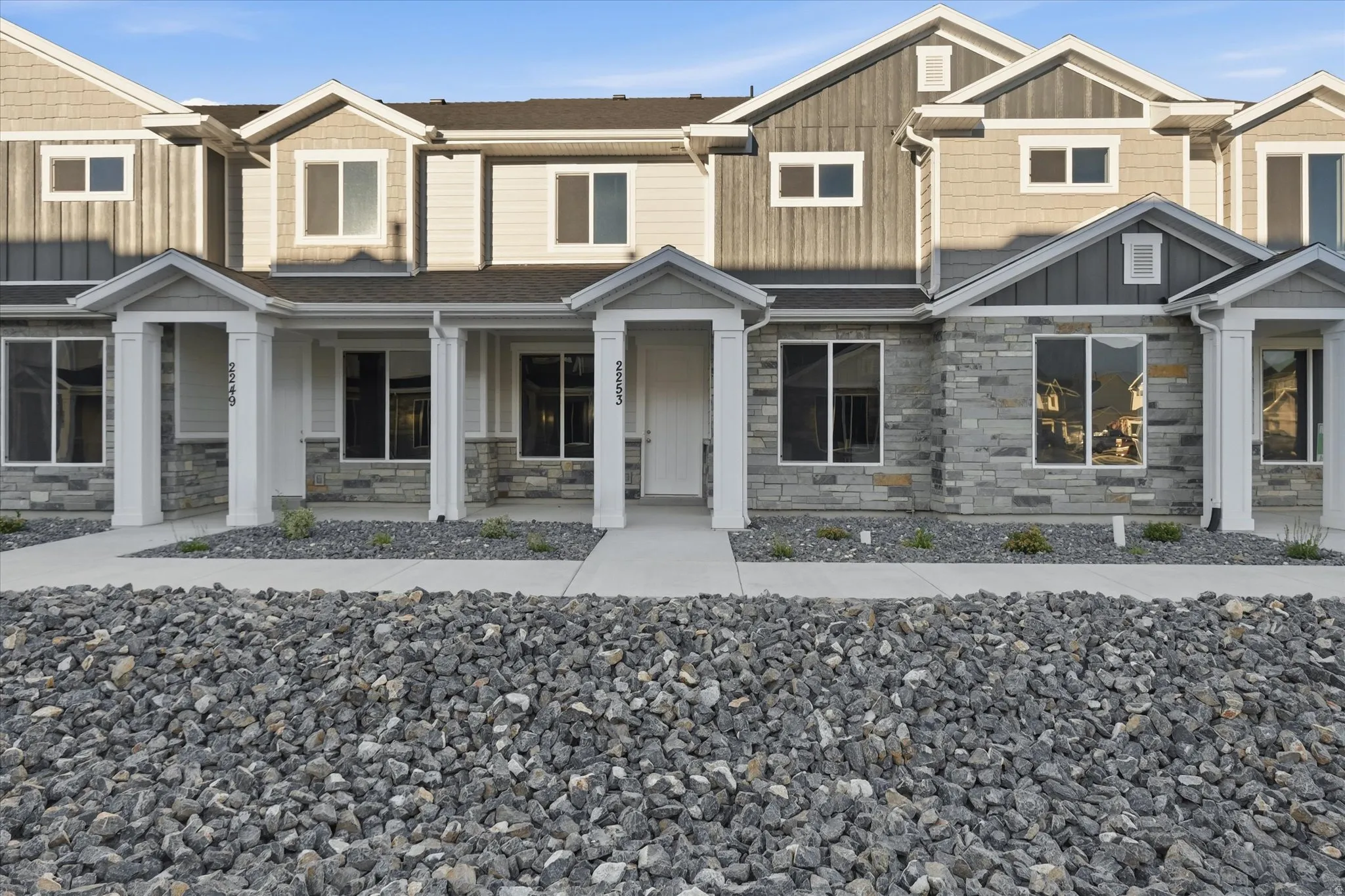 Contemporary multi-level exterior featuring stone veneer, horizontal siding, and vertical board and batten accents