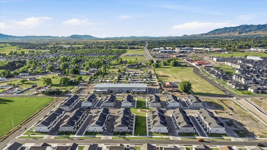 Aerial perspective showcasing a developing community with new construction townhomes featuring light-toned exteriors and dark roofing