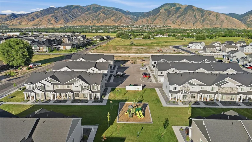 Modern townhome community featuring a central green space with a playground