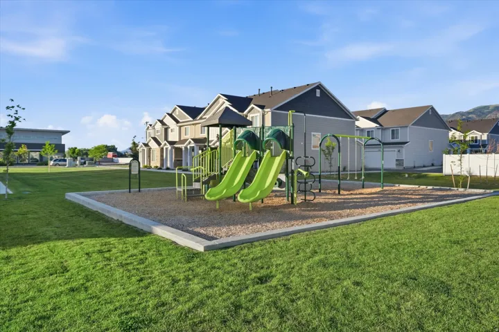 Community playground featuring multiple slides and swings on a gravel surface