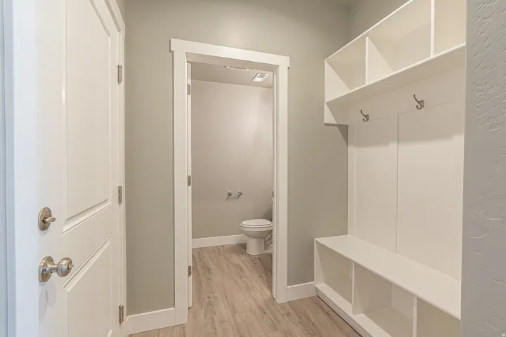 Entryway featuring a built-in mudroom bench with open cubbies, upper shelving, and coat hooks