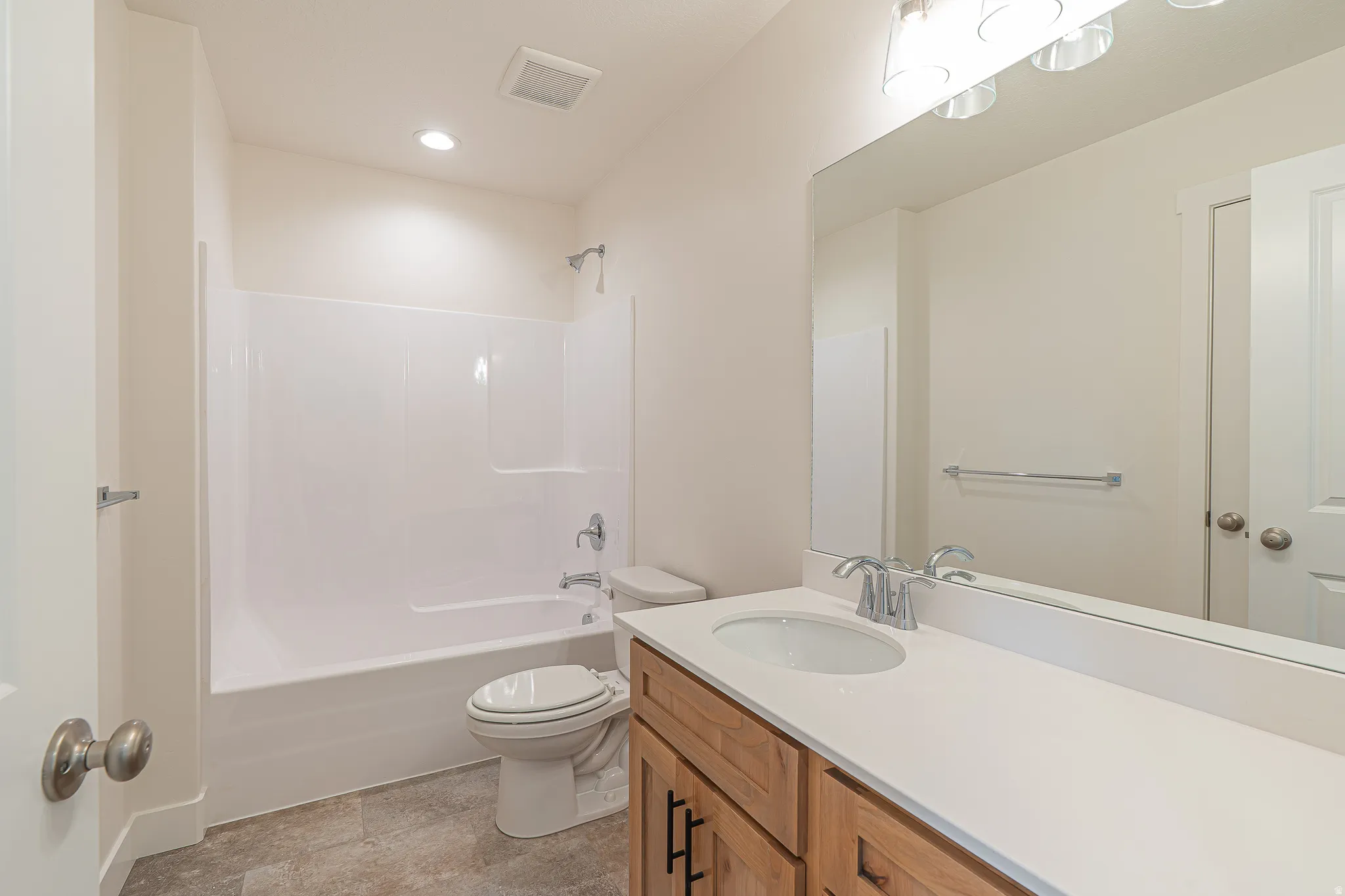 Full bathroom with a white tub and shower combination, chrome fixtures, and neutral-toned wall paint