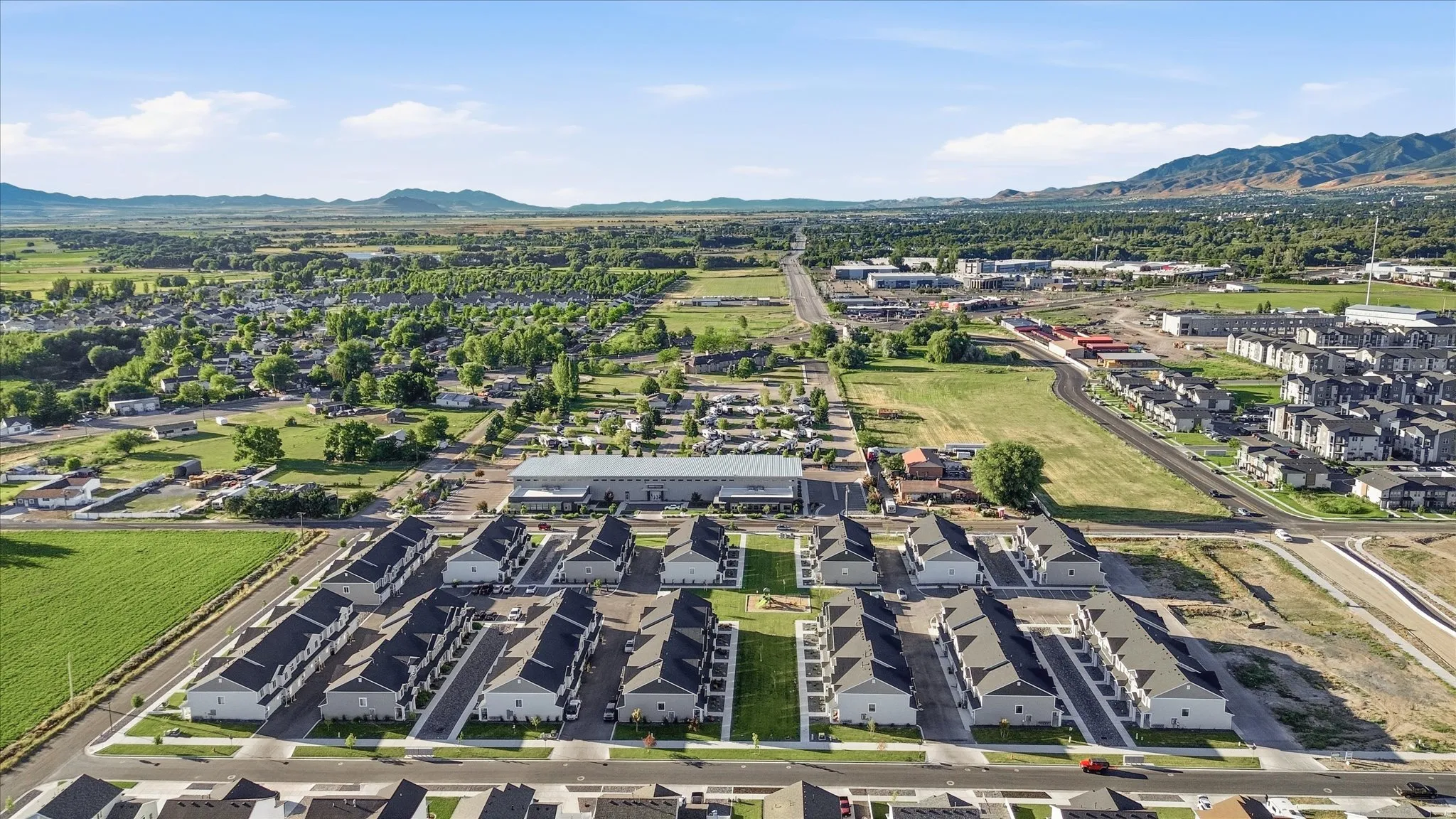 Aerial perspective showcasing a developing community with new construction townhomes featuring light-toned exteriors and dark roofing