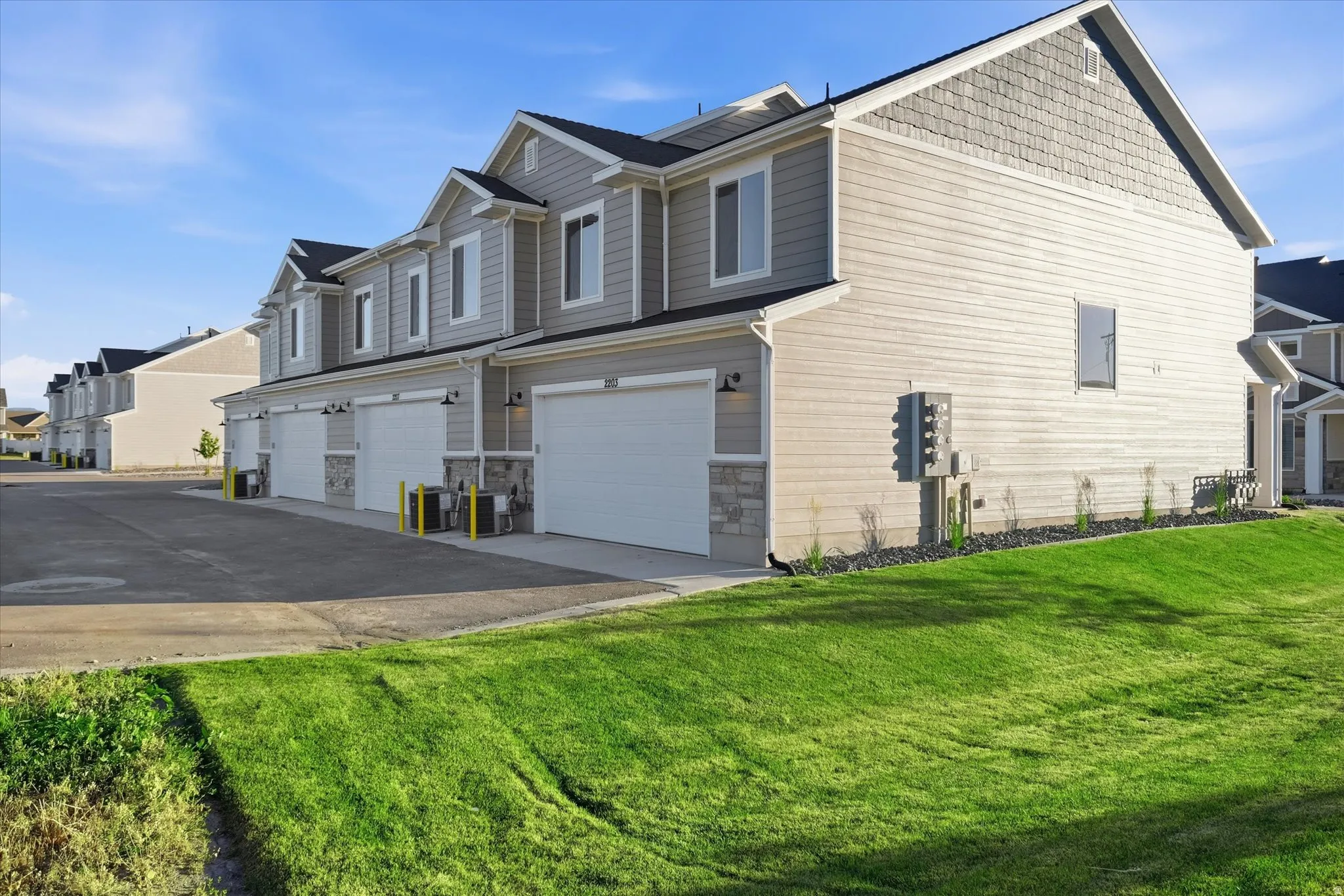 Townhome row with light gray siding and complementary stone accents