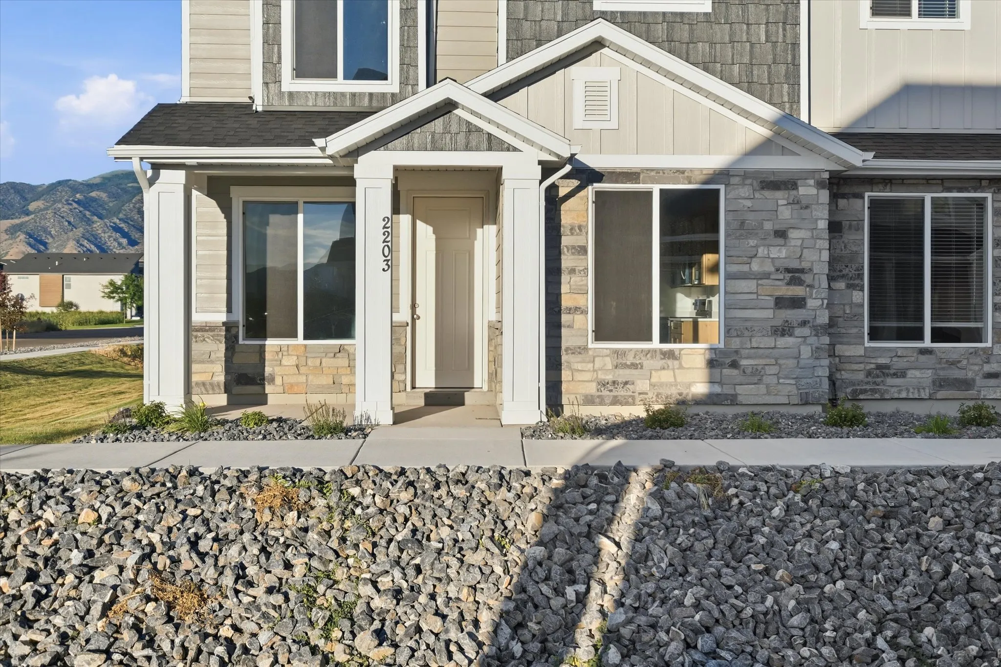 Contemporary facade featuring stone veneer and horizontal siding