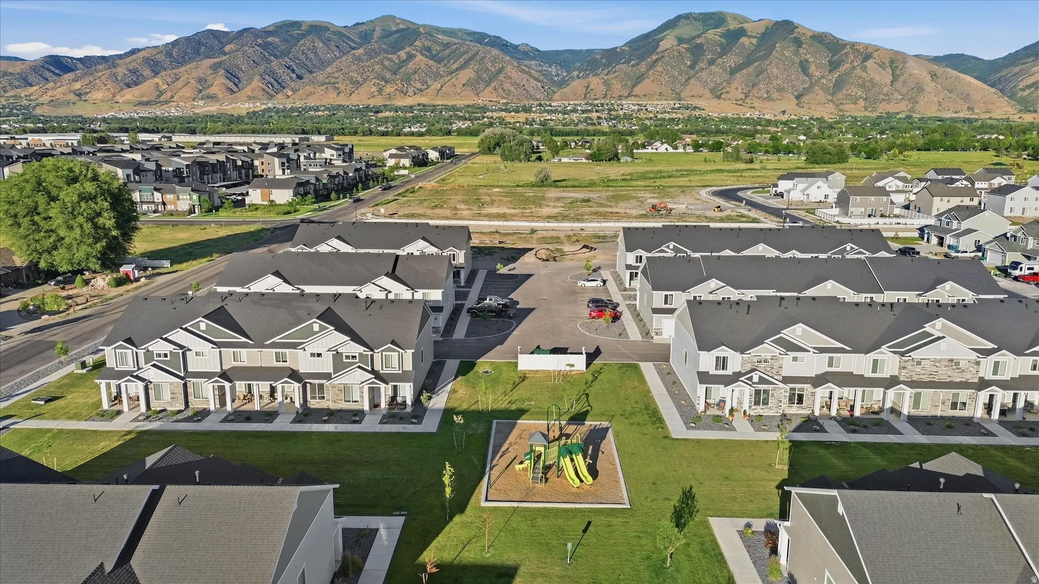 Modern townhome community featuring a central green space with a playground