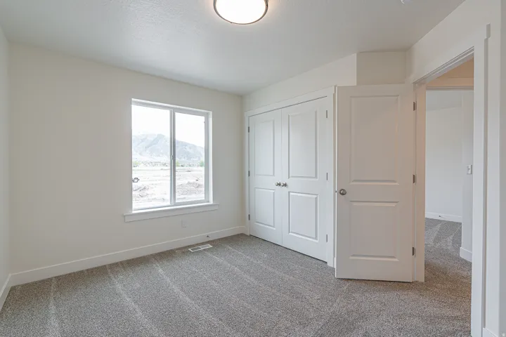 Carpeted interior space featuring a double-panel window with a mountain backdrop