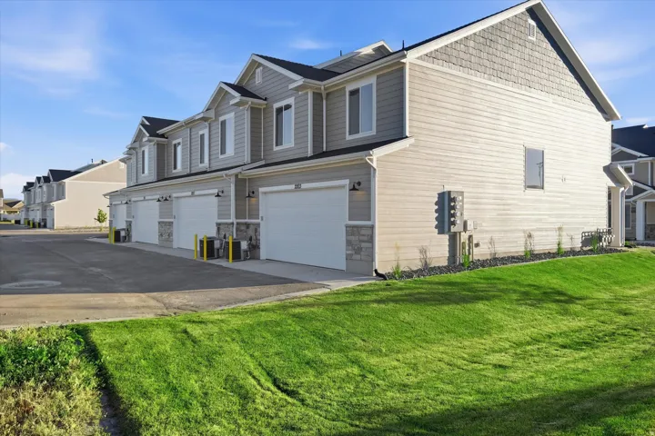 Townhome row with light gray siding and complementary stone accents