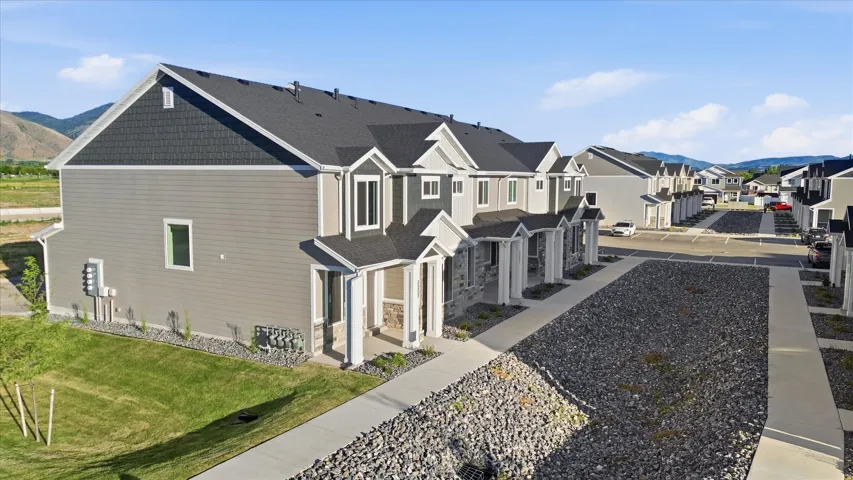 Modern townhome row featuring gray siding, dark shake siding accents, and gabled rooflines