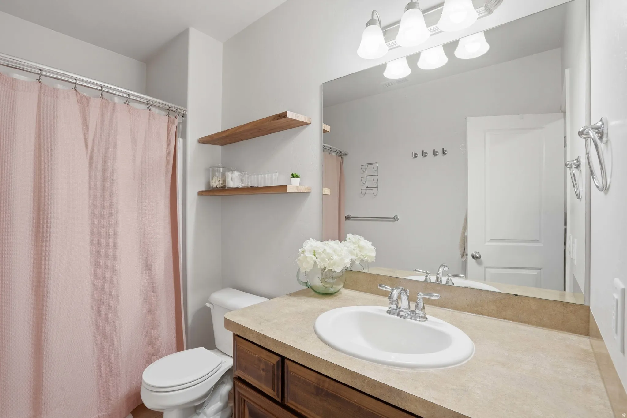 Bathroom featuring a vanity with a light-toned countertop, undermount sink, and chrome fixtures