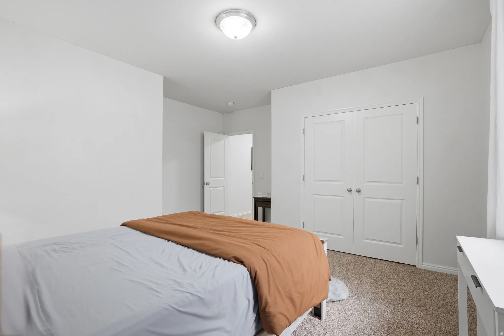 Bedroom featuring a ceiling-mounted light fixture, white walls, and white trim
