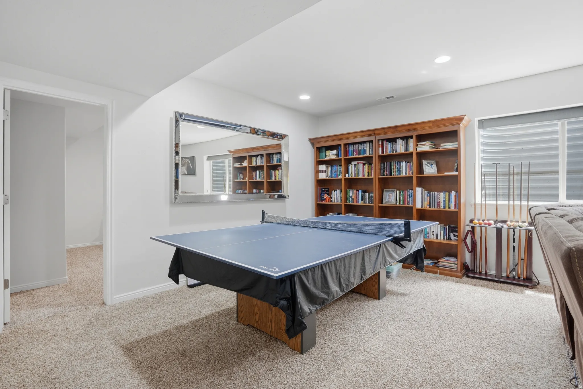 Recreational room featuring carpet flooring, recessed lighting, and wood-finish bookshelfs