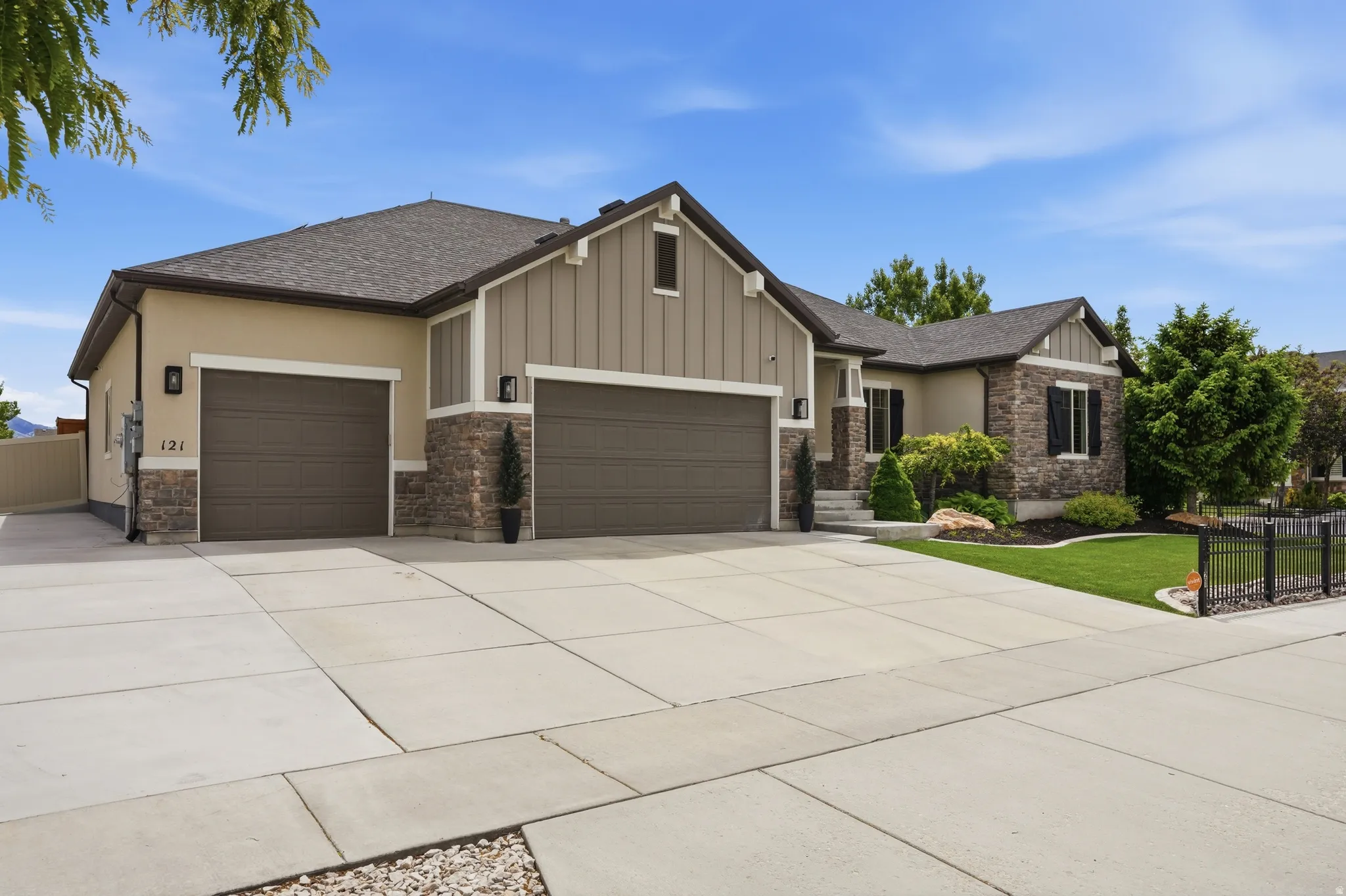 Front exterior featuring a multi-tone facade with stone and vertical siding accents