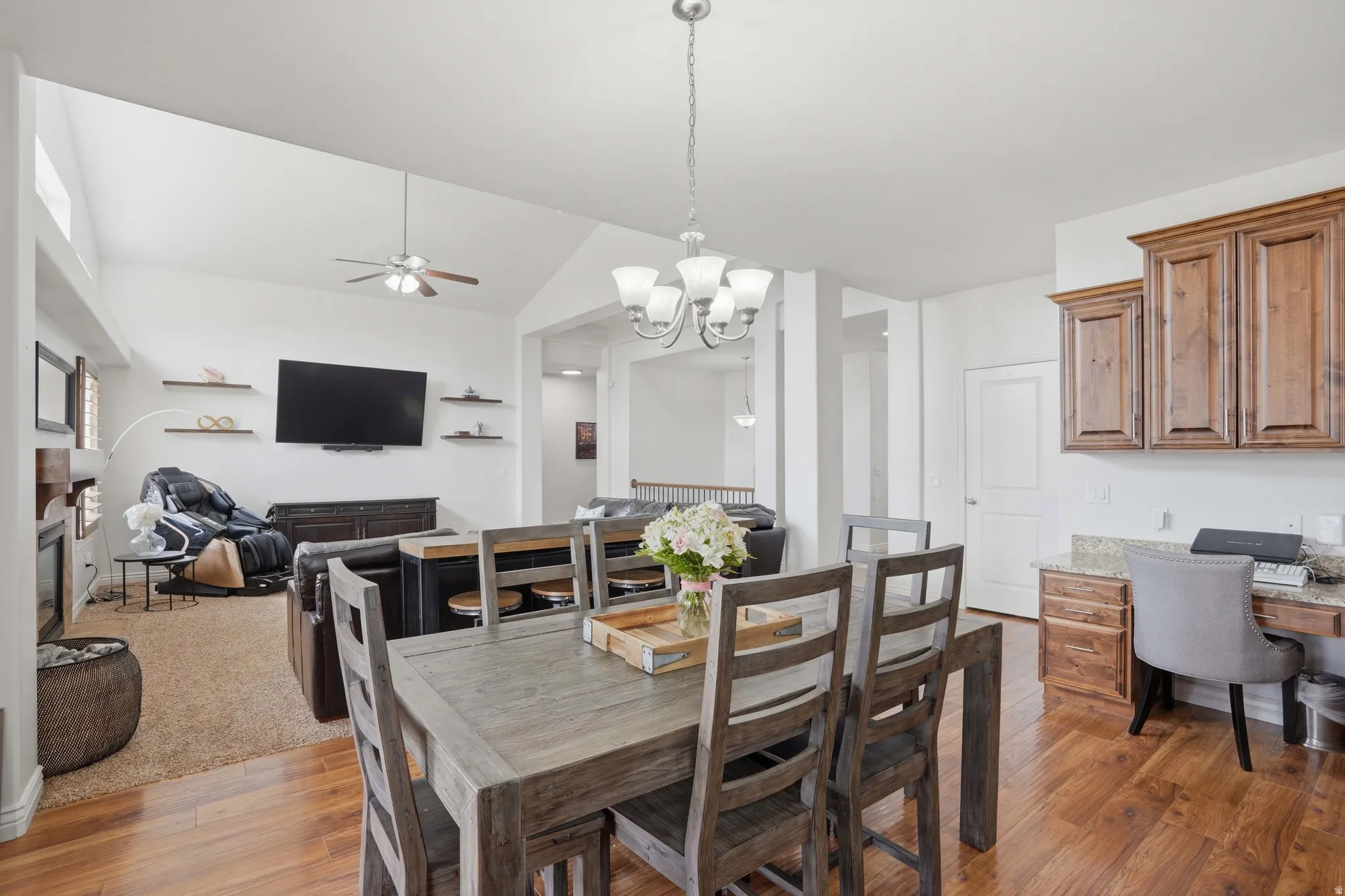 Open concept living space featuring wood-finish flooring and vaulted ceilings