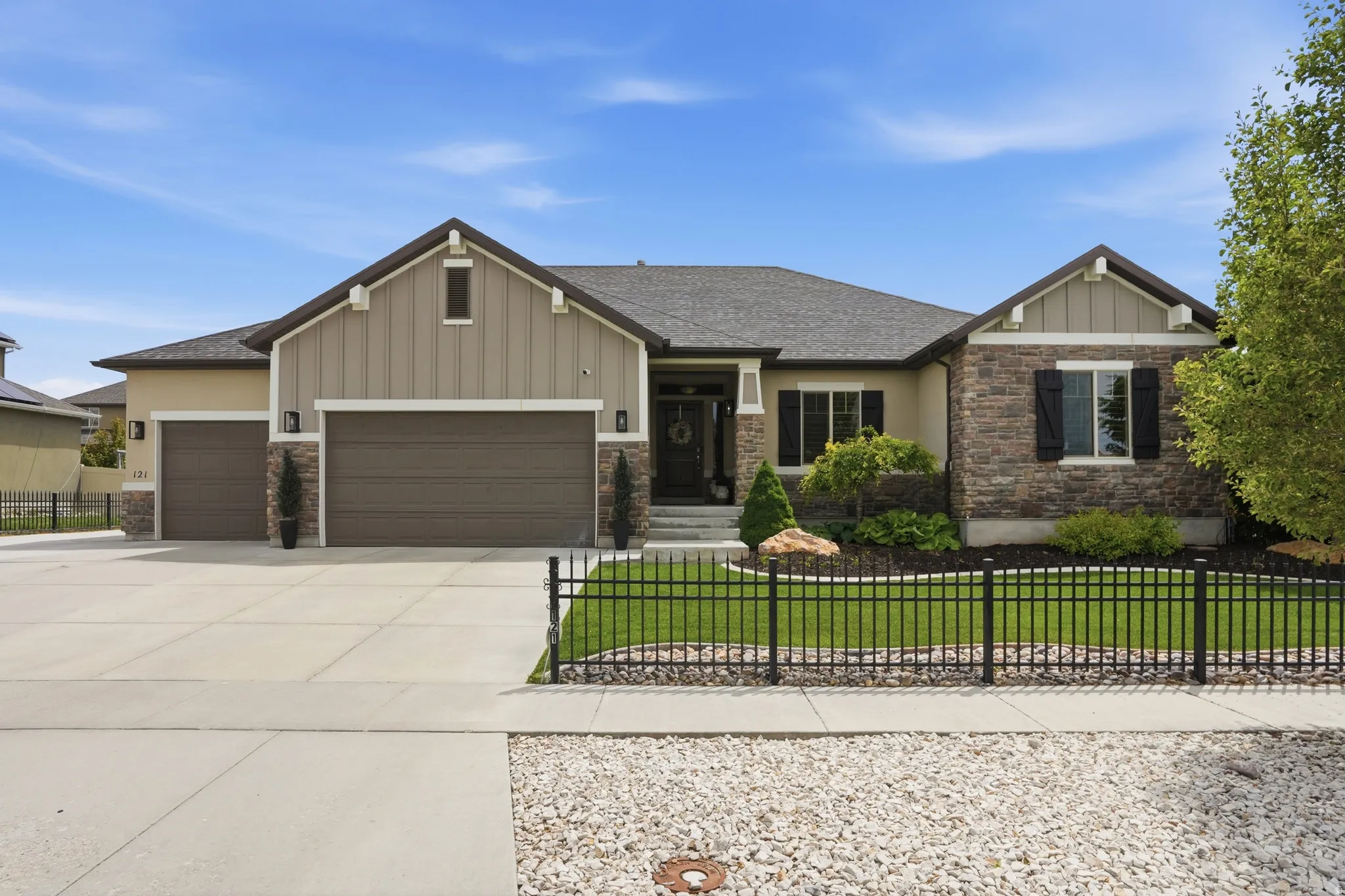 Exterior featuring stone and vertical siding accents, a dark shingle roof, and an attached two-car garage