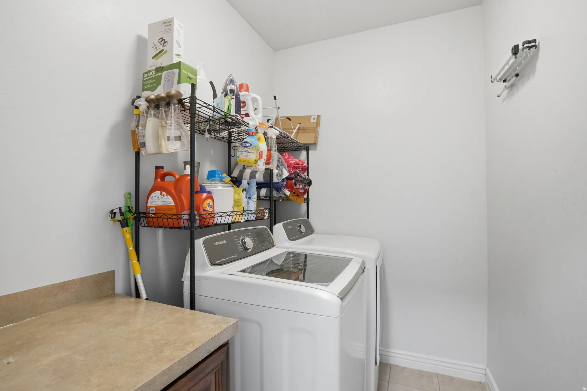 Dedicated laundry area featuring a countertop with storage below, and tiled flooring
