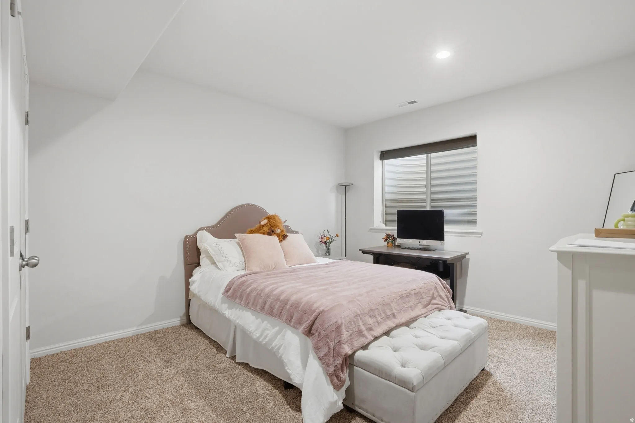 Neutral-toned room with plush carpeting and white baseboards