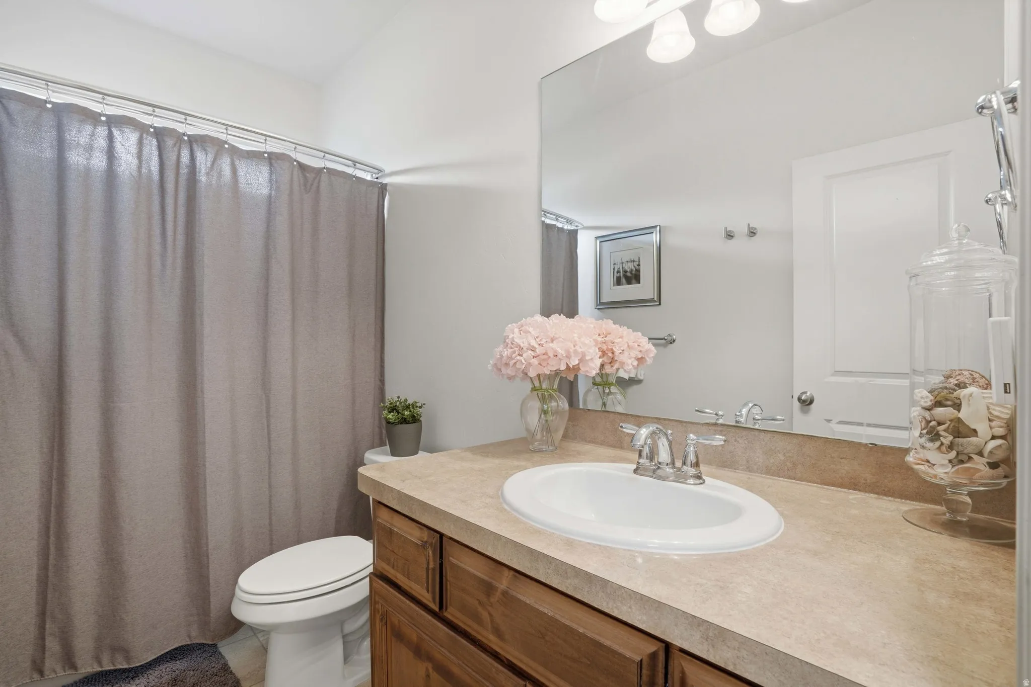 Bathroom vanity featuring a light-toned countertop, undermount sink, and chrome fixtures