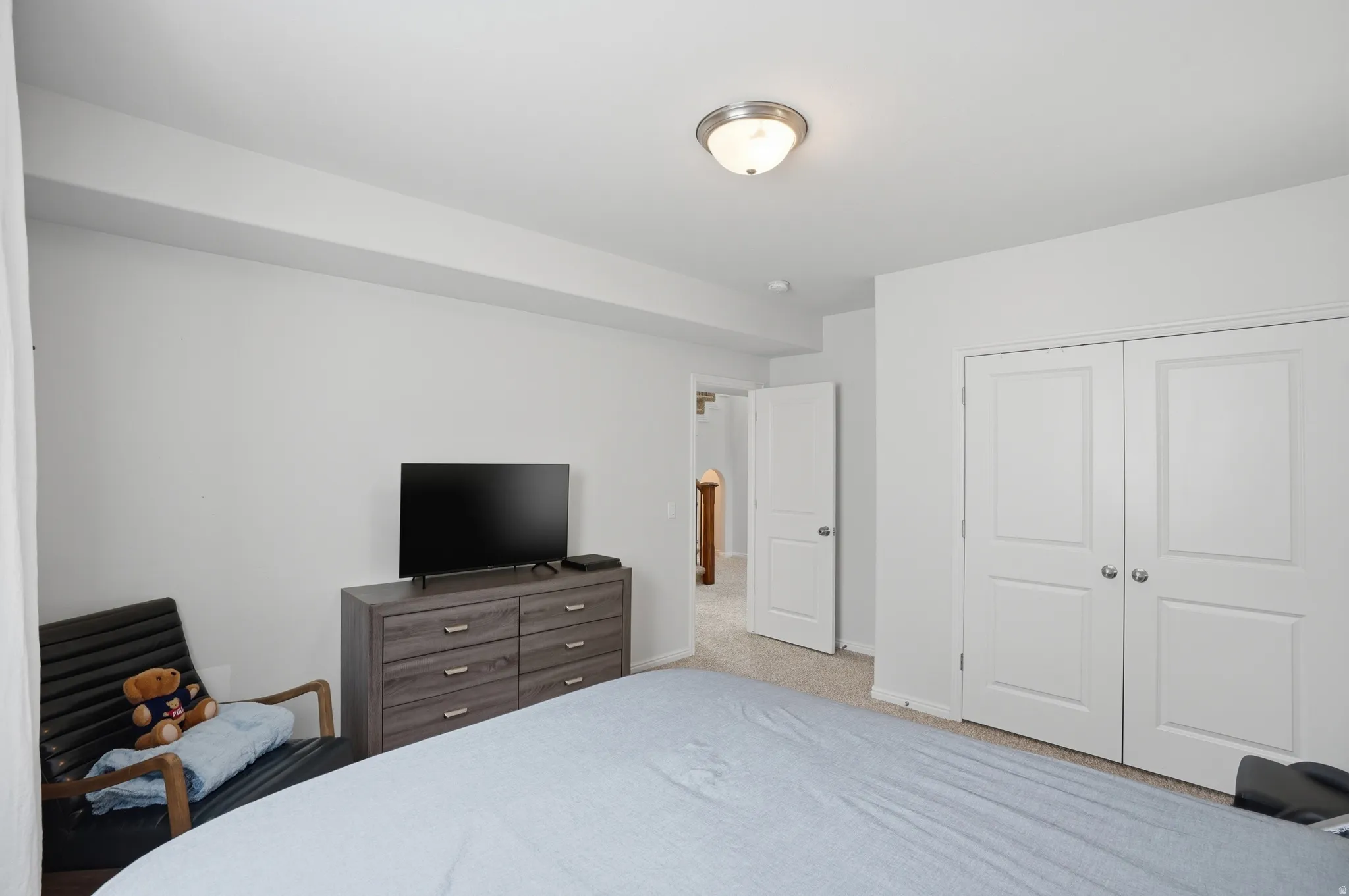 Bedroom featuring neutral wall paint, a flush-mount ceiling light fixture, and a textured carpet