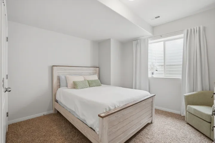 Bedroom featuring neutral wall colors, recessed lighting, a window with blinds and drapes, and plush carpet flooring