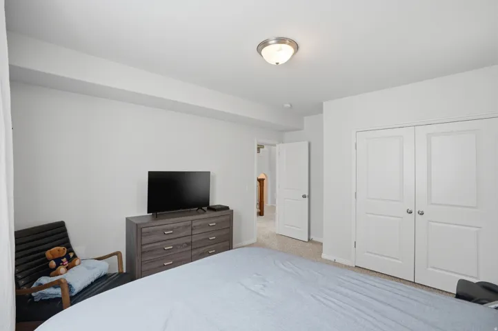 Bedroom featuring neutral wall paint, a flush-mount ceiling light fixture, and a textured carpet