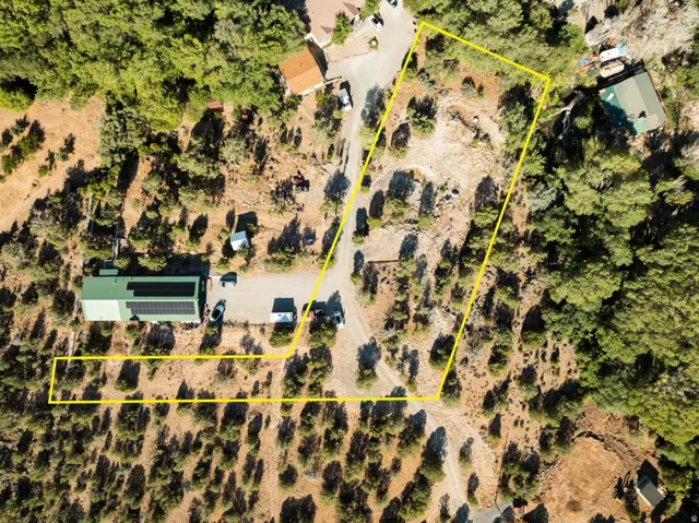 Expansive property outlined by a yellow border, featuring a green-roofed structure equipped with solar panels