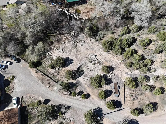 Expansive undeveloped lot featuring a gravel driveway and surrounding natural landscaping