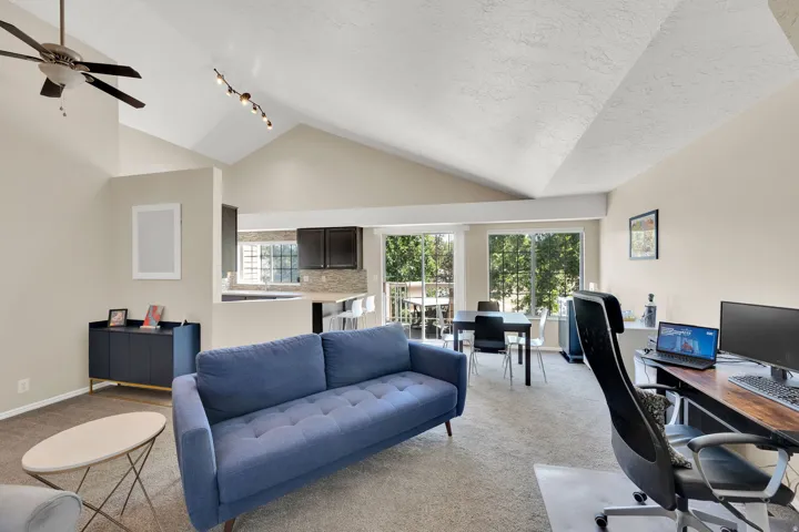 Open concept living area featuring vaulted ceilings and track lighting