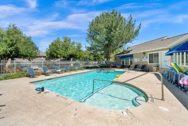 Community swimming pool featuring a concrete deck and a separate spa