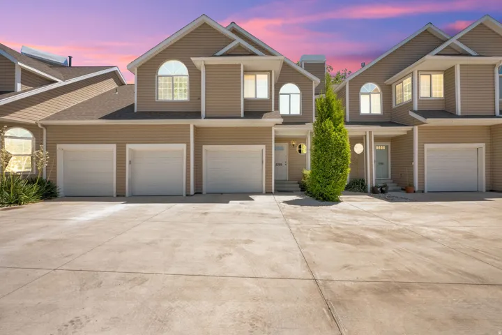 Multi-unit residential property featuring tan siding and white trim