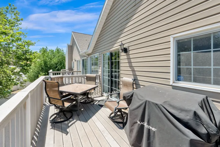 Outdoor deck featuring wood-finish flooring, white railing, and exterior siding