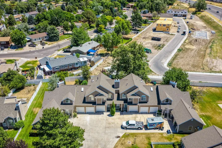 Multi-unit residential structure featuring a gray exterior, multiple pitched roofs, and integrated garages