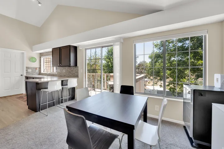 Open-concept living space featuring vaulted ceilings and track lighting
