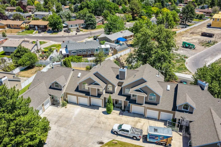 Multi-level property featuring a neutral stucco exterior with multiple gables and a composition shingle roof