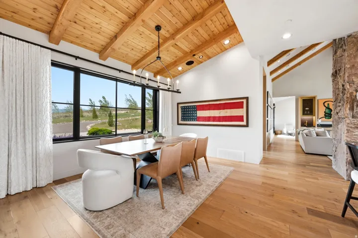 Vaulted wood-plank ceilings with exposed beams complement the wide-plank wood flooring