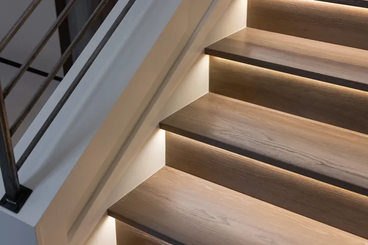 Staircase featuring wood-finish treads with integrated under-tread lighting